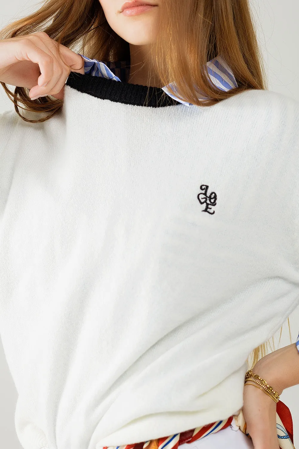 White sweater with contrasting collar and love logo on chest